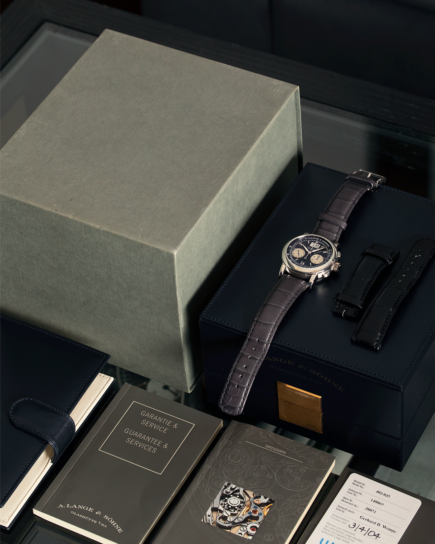 Brand: A. Lange & Sohne Year: 2004 Model: Datograph Reference Number: 403.035 Material: Platinum Movement: Manual Winding L951.1 Case Diameter: 39mm Bracelet/Strap: A. Lange & Sohne Black Alligator Strap with signed Platinum Tang Buckle and Custom Made Grey Jean Rousseau for ALS Alligator Strap
