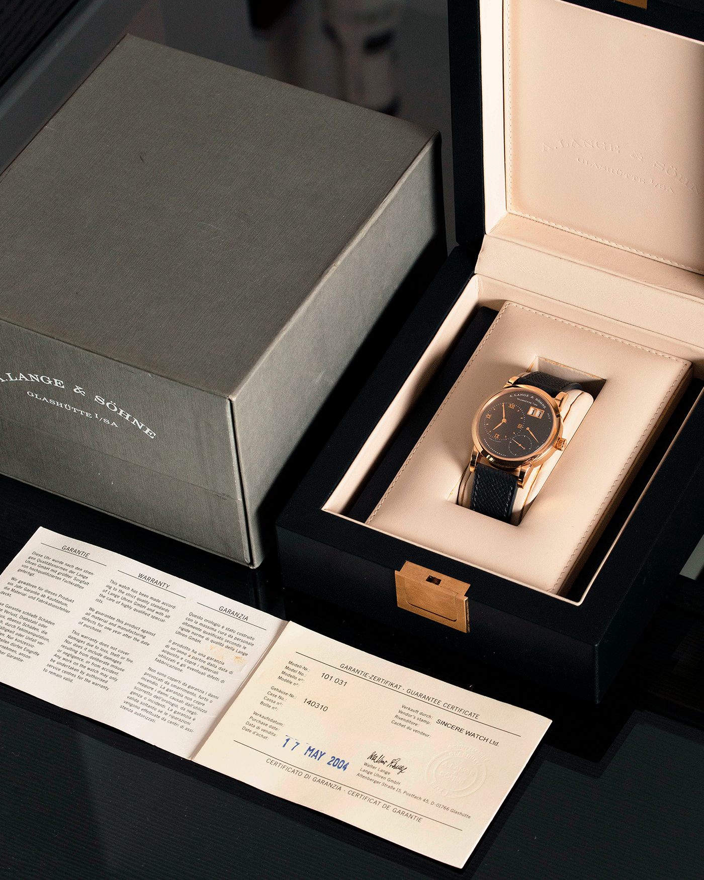 Brand: A. Lange & Sohne Year: 2004 Model: Lange 1 Reference Number: 101.031 Material: 18k Rose Gold Movement: Manual Winding L901.5 Case Diameter: 38.5mm Bracelet/Strap: Nostime Anthracite Textured Calf with 18k Rose Gold Tang Buckle