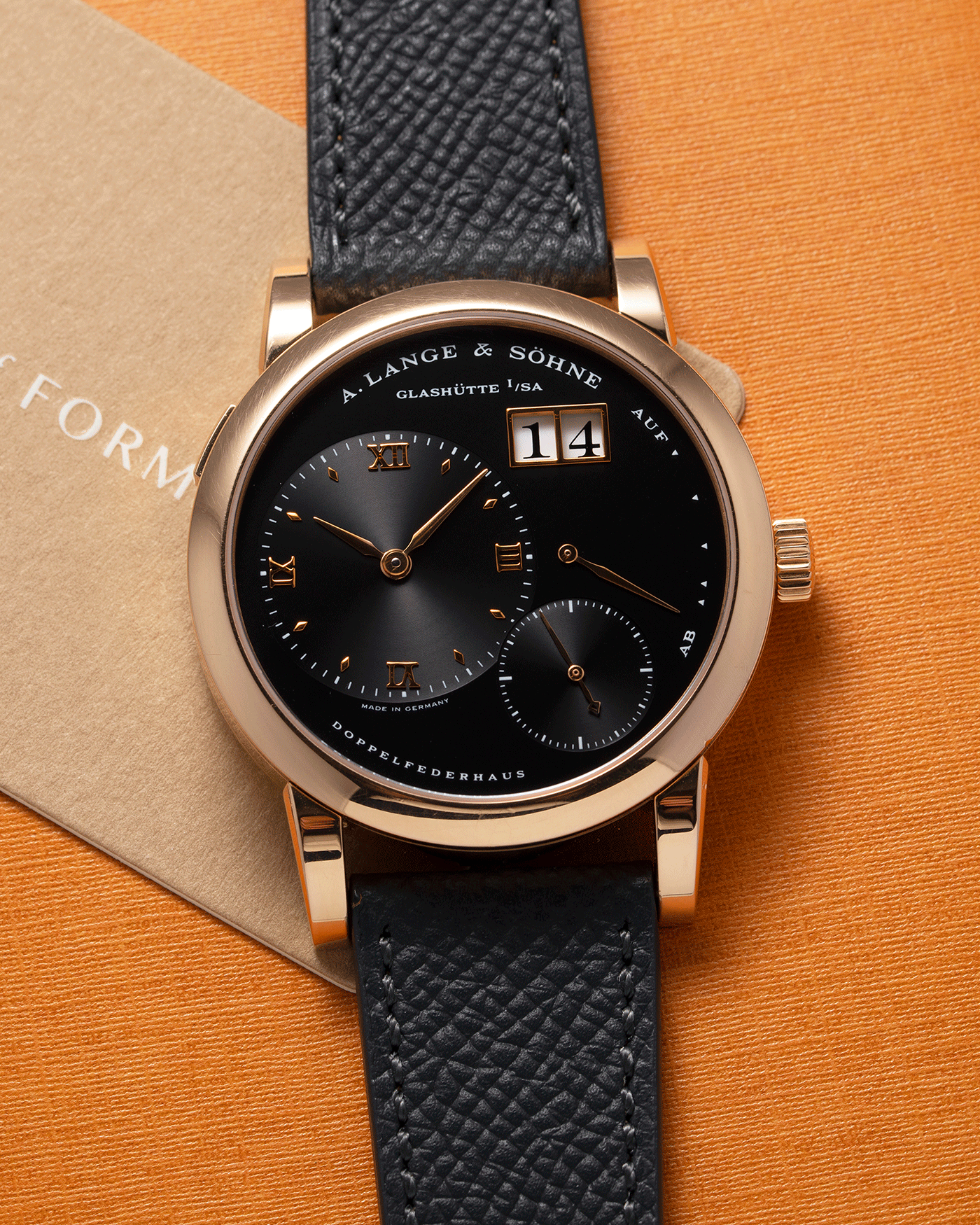 Brand: A. Lange & Sohne Year: 2004 Model: Lange 1 Reference Number: 101.031 Material: 18k Rose Gold Movement: Manual Winding L901.5 Case Diameter: 38.5mm Bracelet/Strap: Nostime Anthracite Textured Calf with 18k Rose Gold Tang Buckle