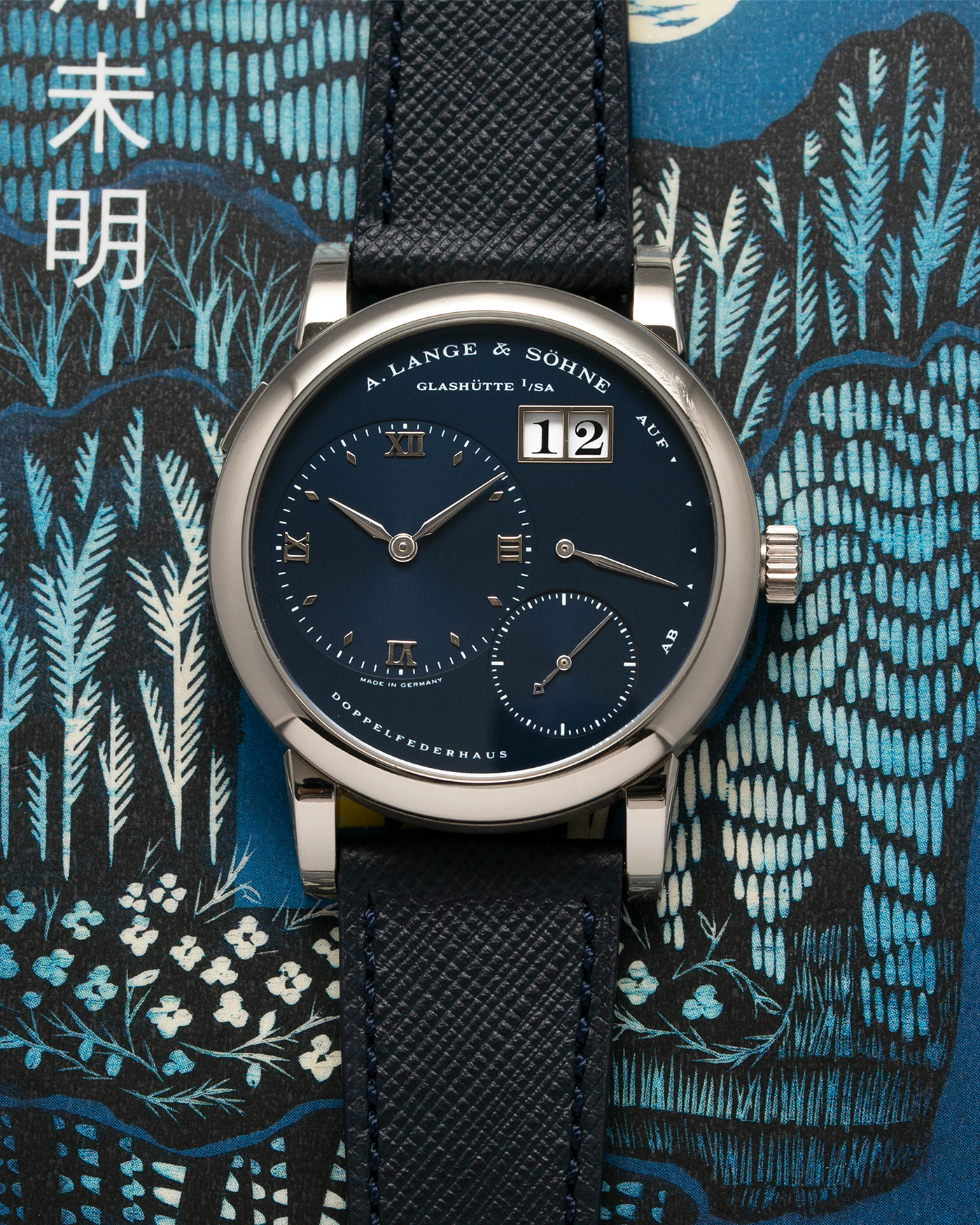 Brand: A. Lange & Sohne Year: 2000’s Model: Lange 1  Reference Number: 101.027 Material: 18k White Gold Movement: Manual Winding L901.5 Case Diameter: 38.5mm Bracelet/Strap: Molequin Navy Blue Textured Calf with 18k White Gold A. Lange & Sohne Tang Buckle