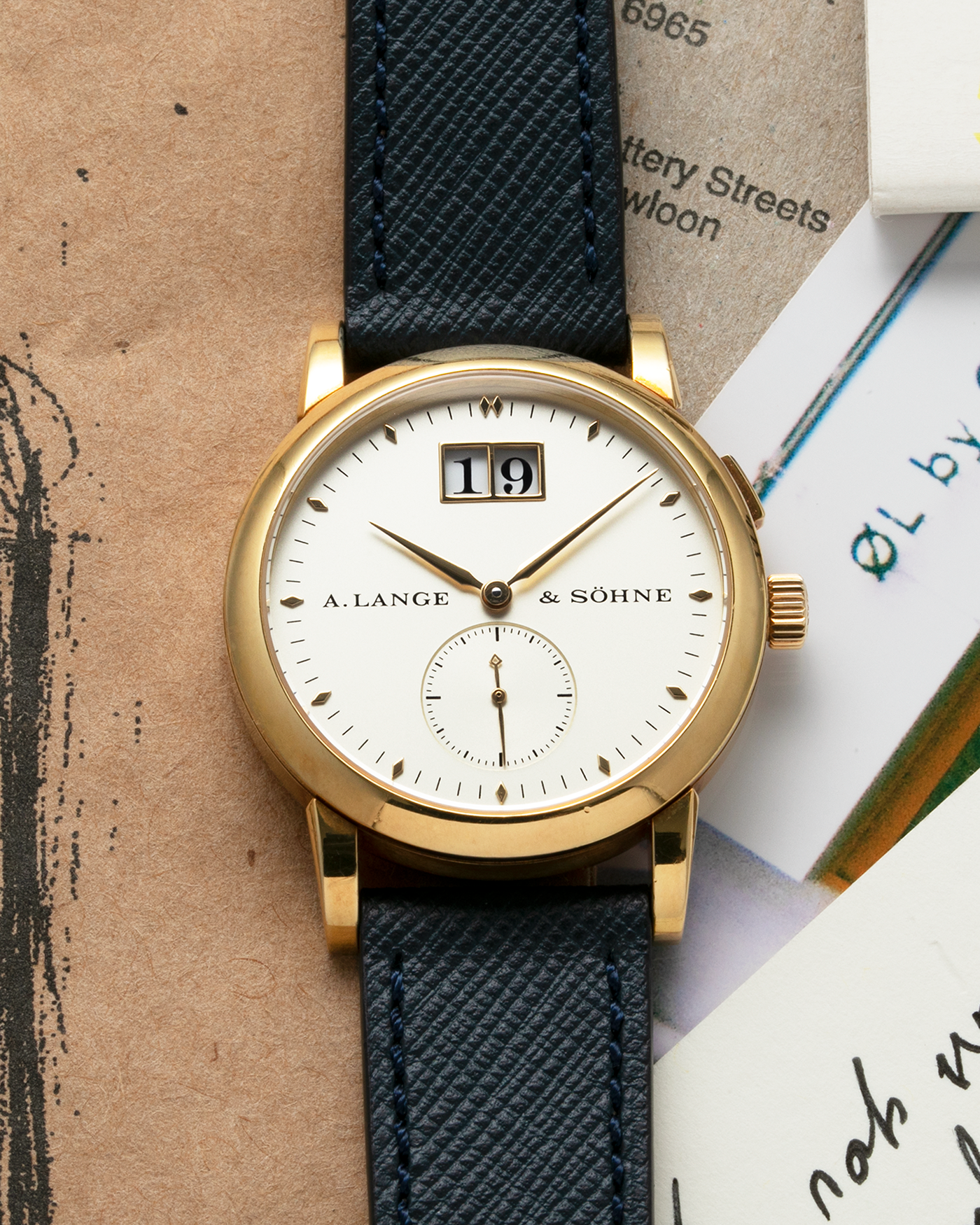 Brand: A. Lange & Sohne Year: Between 1994 - 1996 Model: Saxonia   Reference Number: 102.011 Material: 18-carat Yellow Gold Movement: Cal. L911.3, Manual-Wind Case Diameter: 34mm x 9.1mm Bracelet/Strap: Navy Blue Molequin Textured Leather and A. Lange & Sohne Black Alligator with Signed 18-carat Yellow Gold Tang Buckle
