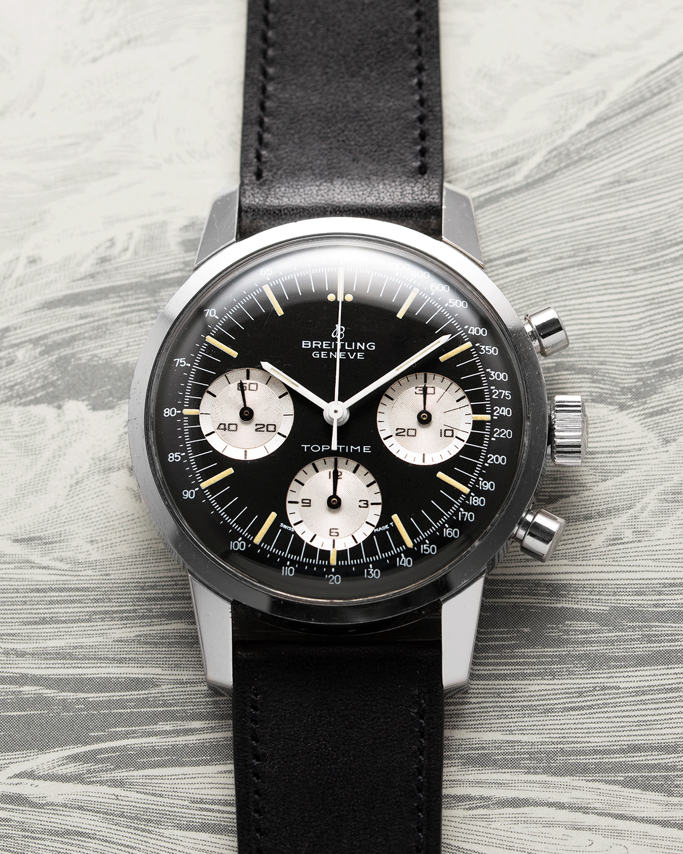 Brand: Breitling Year: 1960’s Model: Top Time Reference Number: 810 Material: Stainless Steel Movement: Manually wound Venus 178 Case Diameter: 38mm Lug Width: 18mm Bracelet/Strap: Nostime Black Calf