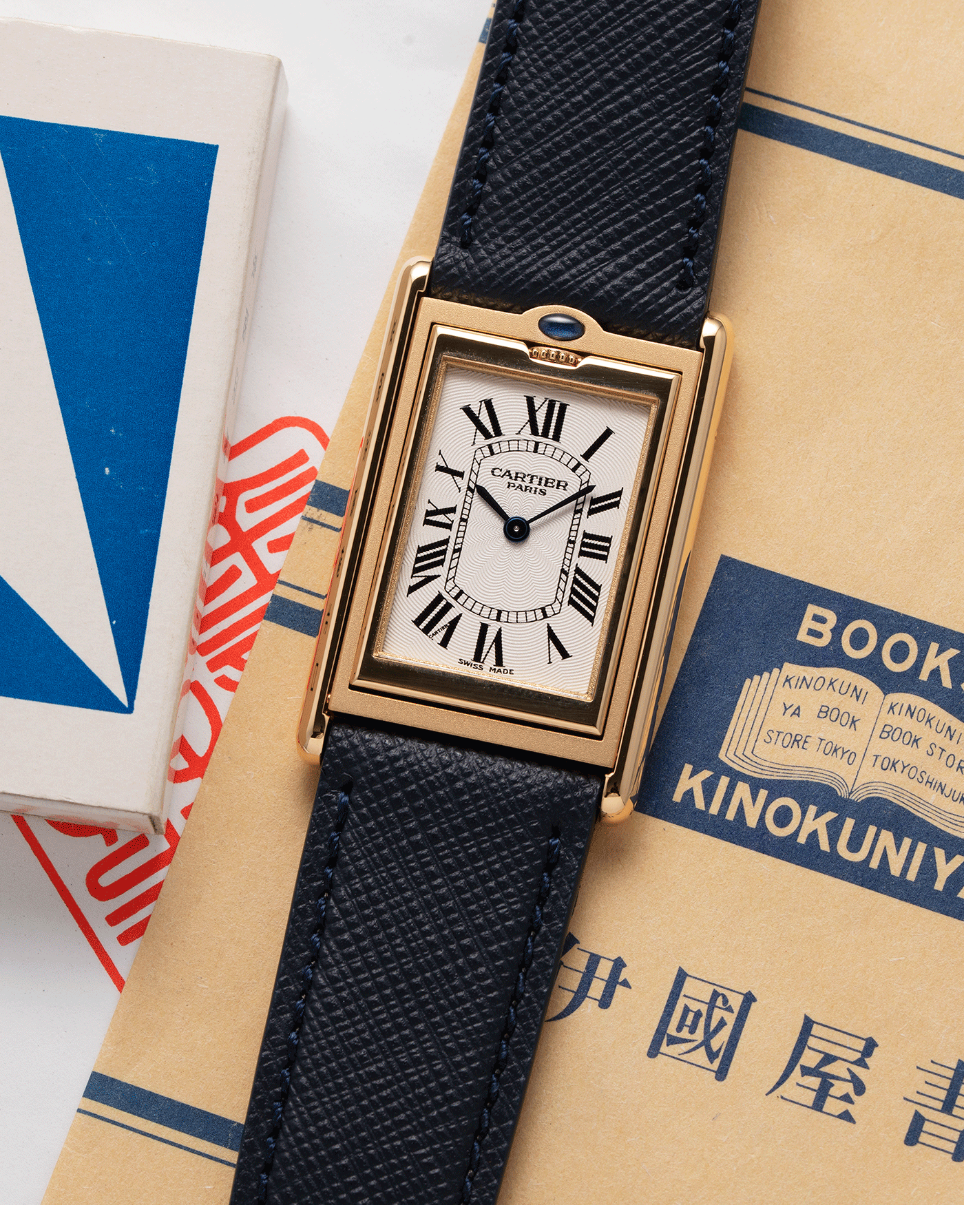 Brand: Cartier Year: 2000 Model: Tank Basculante Material: 18k Yellow Gold Movement: Cartier Cal. 610 (F. Piguet) Case Diameter: 25mm x 39mm Strap: Molequin Navy Blue Textured Calf and 18k Yellow Gold Deployant Clasp