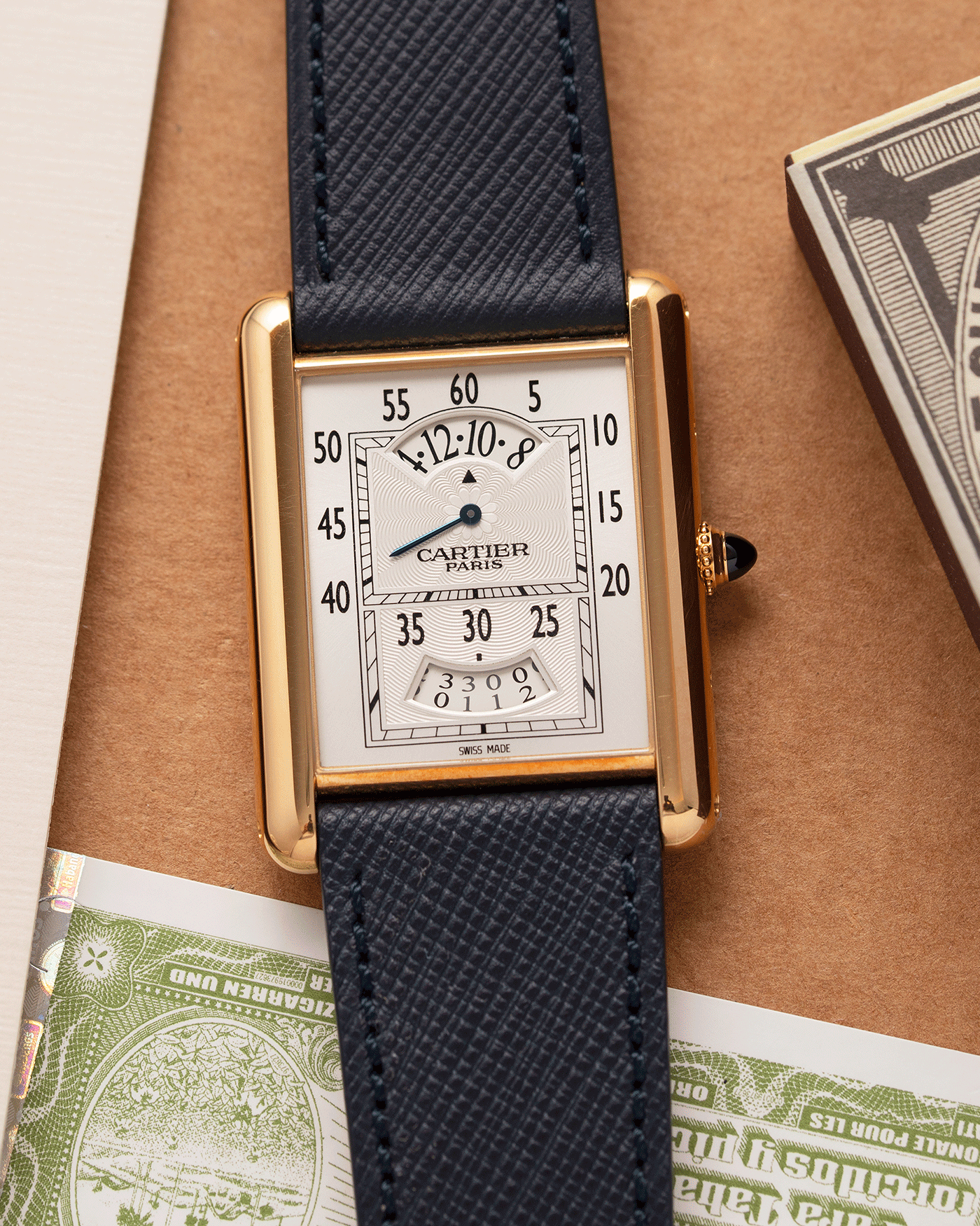 Brand: Cartier Year: 2005 Model: Collection Prive Tank Louis Cartier Wandering Hours Reference: 2918 Material: 18k Rose Gold Movement: Piaget-Based Manually Wound Cal. 9902 MC Case Diameter: 28mm width, 40.5mm lug to lug Strap: Navy Blue Molequin Textured Calf Strap with separate 18k Cartier Rose Gold Deployant