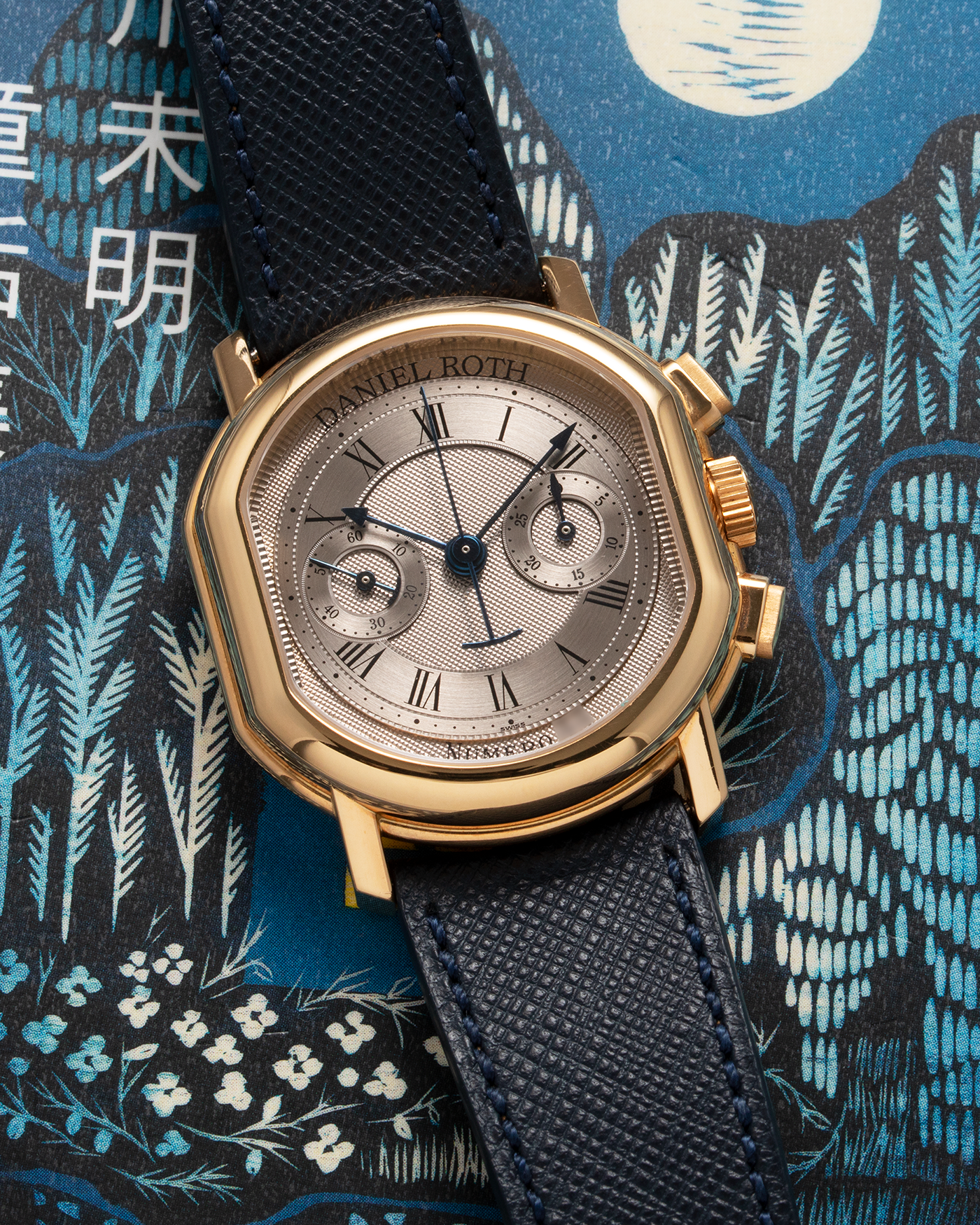 Brand: Daniel Roth Year: 1990’s Model: C147 Material: 18k Yellow Gold Movement: Lemania 2320 Case Diameter: 35mm X 38mm Strap: Molequin Navy Blue Textured Calf Strap and 18k Yellow Gold Daniel Roth Tang Buckle