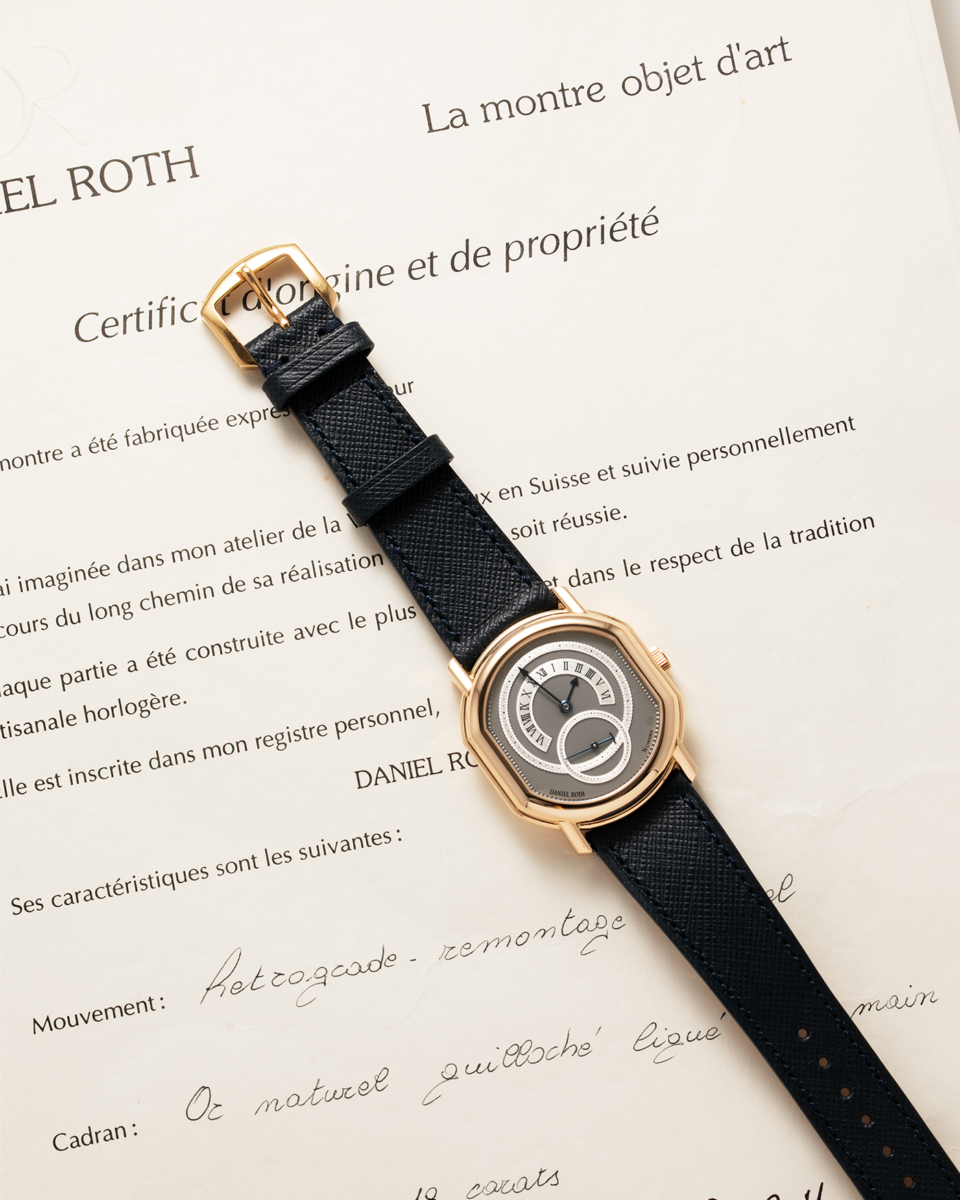 Brand: Daniel Roth Year: 1990’s Model: C127 Material: 18k Yellow Gold Movement: Lemania 27LN with Retrograde Function Case Diameter: 35mm X 38mm Strap: Molequin Navy Blue Textured Calf Strap and 18k Yellow Gold Daniel Roth Tang Buckle