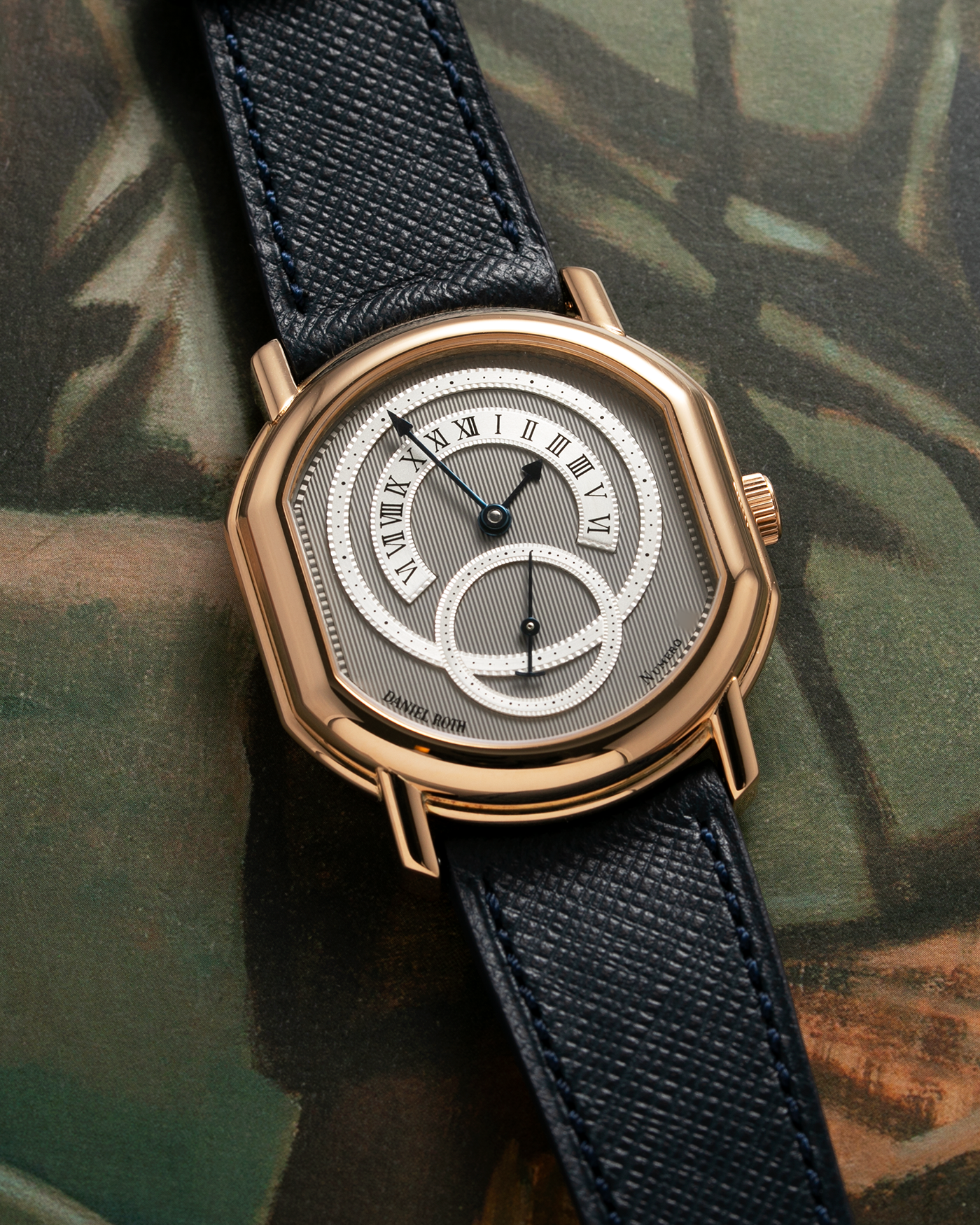 Brand: Daniel Roth Year: 1990’s Model: C127 Material: 18k Yellow Gold Movement: Lemania 27LN with Retrograde Function Case Diameter: 35mm X 38mm Strap: Molequin Navy Blue Textured Calf Strap and 18k Yellow Gold Daniel Roth Tang Buckle