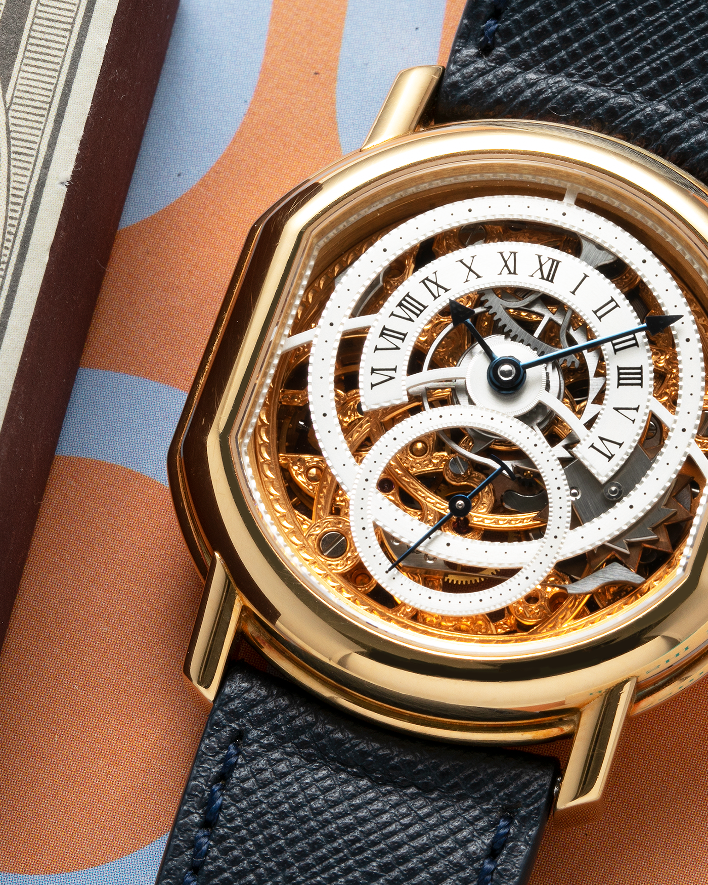 Brand: Daniel Roth Year: 1990’s Model: 2127 Skeleton Material: 18k Yellow Gold Movement: Lemania 27LN with Retrograde Function Case Diameter: 35mm X 38mm Strap: Molequin Navy Blue Textured Calf Strap and 18k Yellow Gold Daniel Roth Tang Buckle