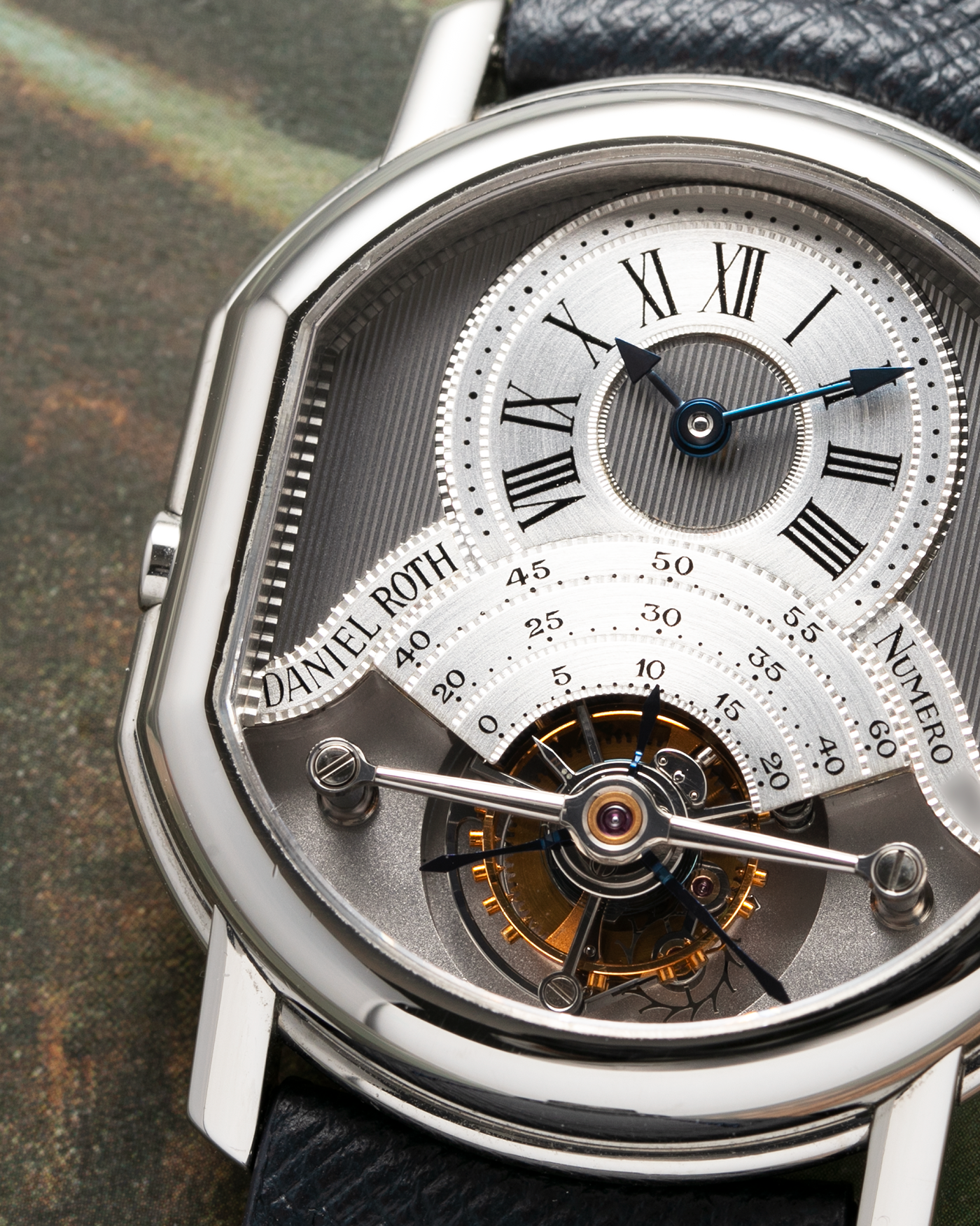 Brand: Daniel Roth Year: 1990’s Model: 2187 Material: Stainless Steel Movement: Cal. DR 307 One-Minute Tourbillon Regulator Case Diameter: 35mm X 38mm Strap: Molequin Navy Blue Textured Calf and Stainless Steel Deployant Clasp
