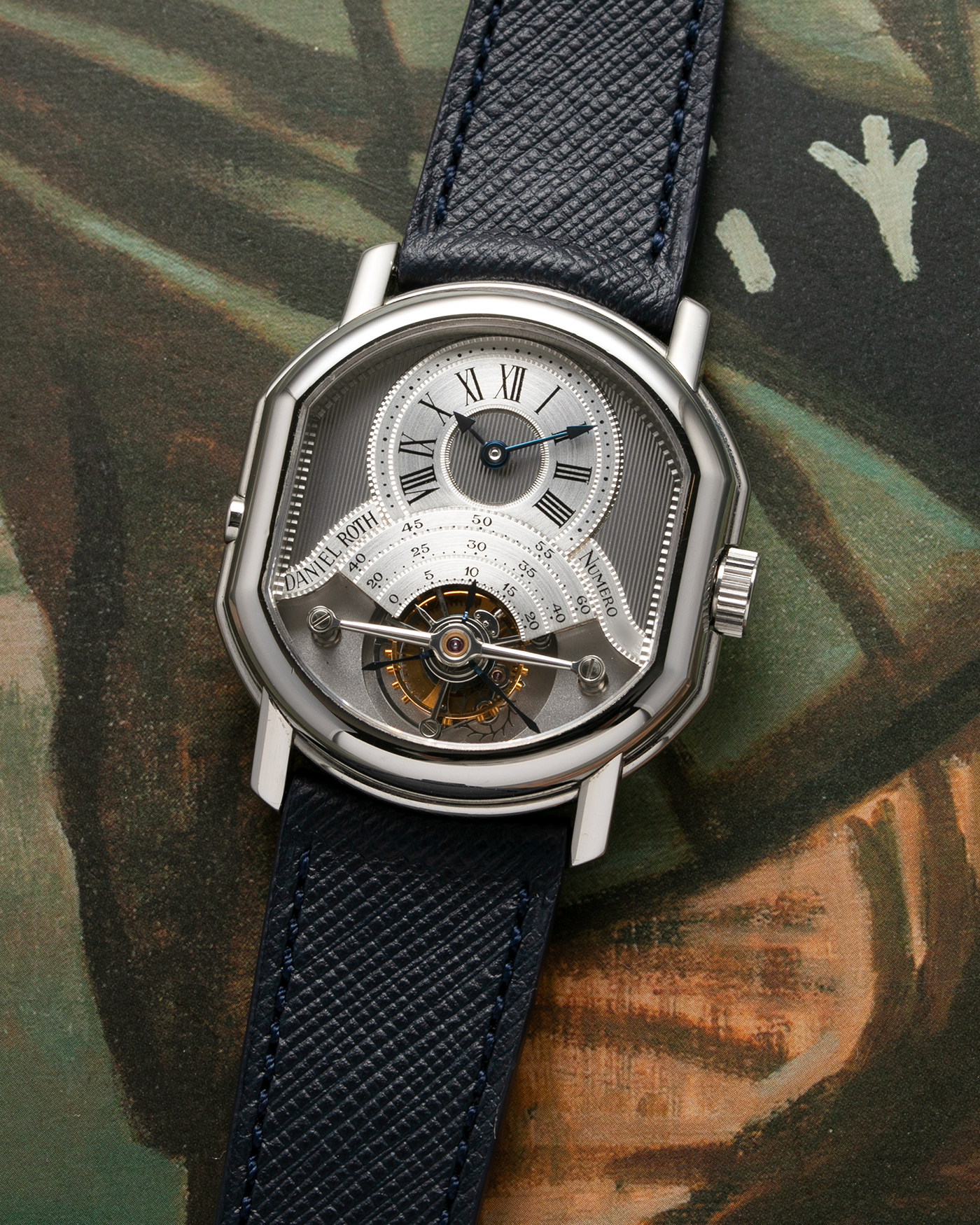 Brand: Daniel Roth Year: 1990’s Model: 2187 Material: Stainless Steel Movement: Cal. DR 307 One-Minute Tourbillon Regulator Case Diameter: 35mm X 38mm Strap: Molequin Navy Blue Textured Calf and Stainless Steel Deployant Clasp