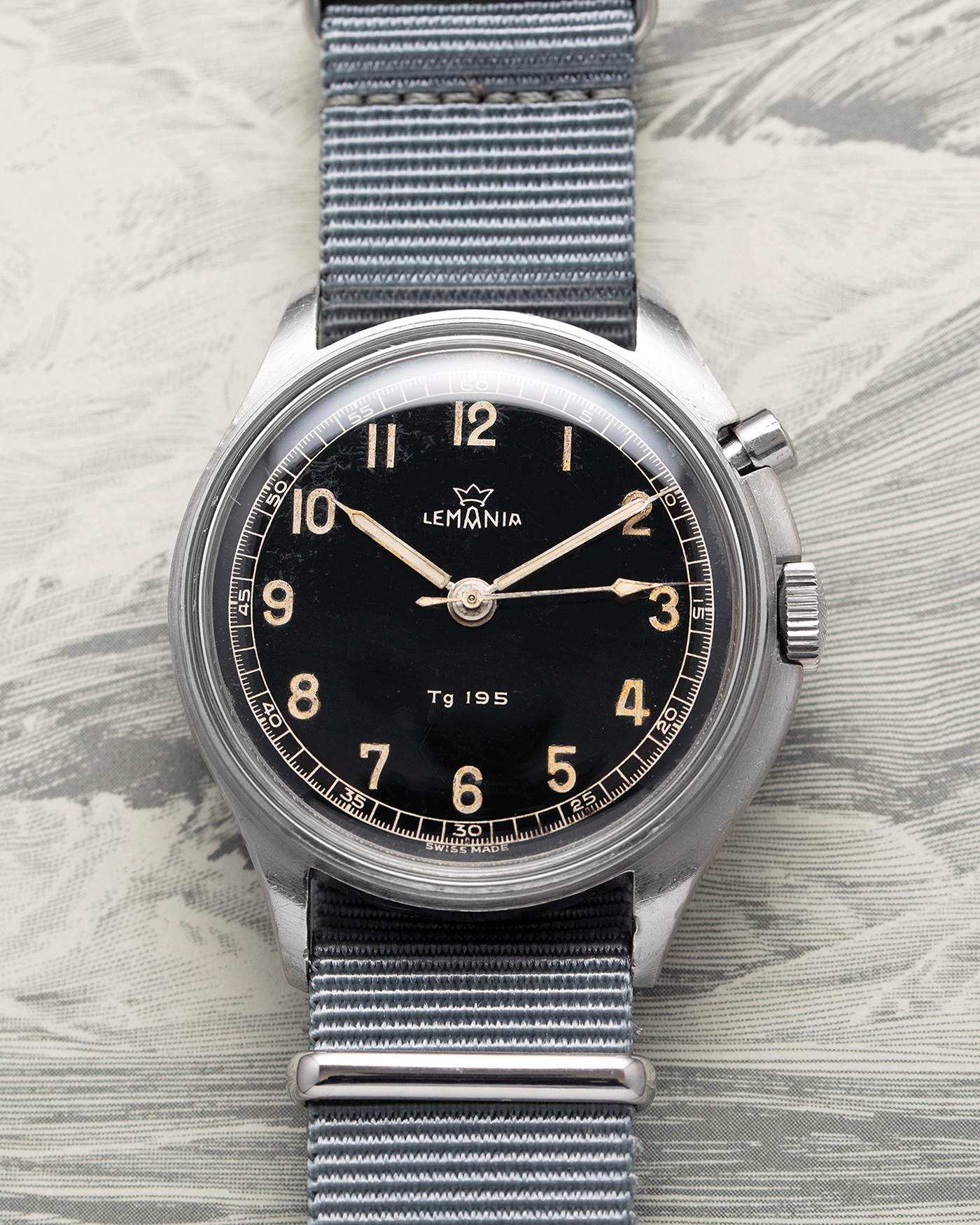 Brand: Lemania Year: 1957 Model: TG 195 Material: Stainless Steel Movement: Cal. 2225 Case Diameter: 40mm Lug Width: 20mm Bracelet/Strap: Grey NATO Strap