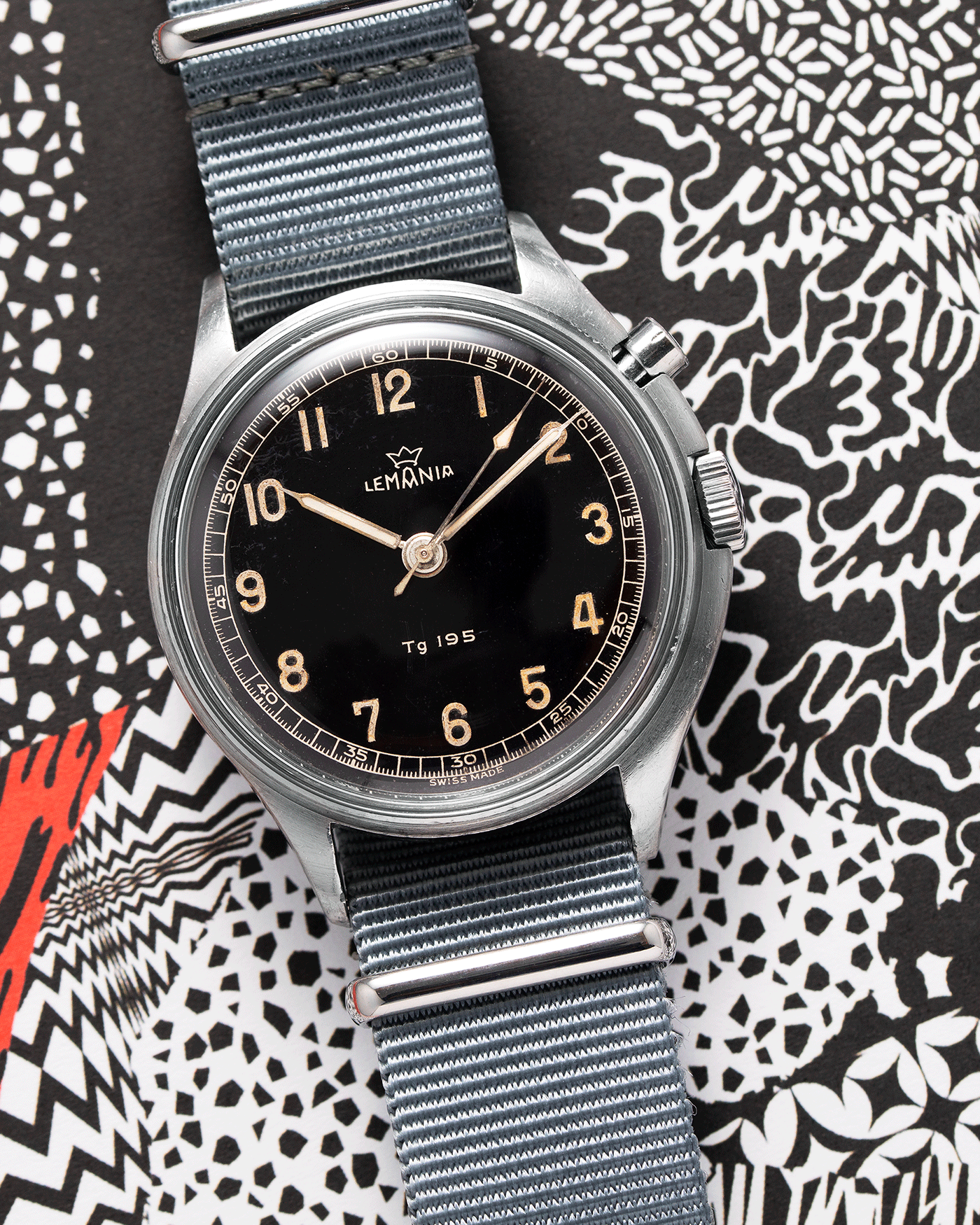 Brand: Lemania Year: 1957 Model: TG 195 Material: Stainless Steel Movement: Cal. 2225 Case Diameter: 40mm Lug Width: 20mm Bracelet/Strap: Grey NATO Strap